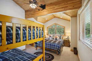 Bedroom featuring wood ceiling, ceiling fan, vaulted ceiling, and carpet flooring