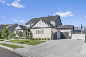 View of front of property with a garage and a front lawn