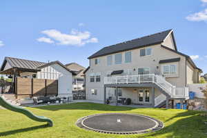 Rear view of house featuring a patio area, french doors, and a lawn