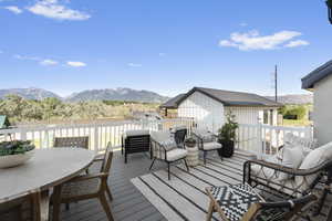 Deck with a mountain view, pool house in the background