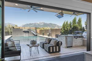 View of patio / terrace with pool water feature, a fenced in pool, a mountain view, a grill