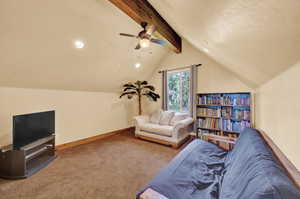 Living room with carpet flooring, ceiling fan, and vaulted ceiling with beams