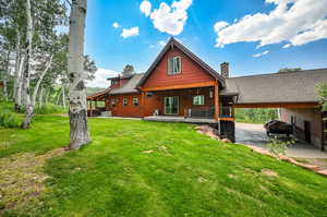 Back of property featuring a porch, a yard, and a carport