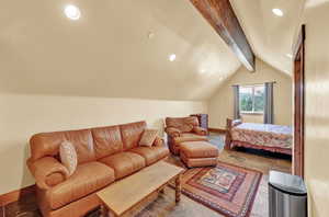 Bedroom with tile patterned floors and lofted ceiling with beams