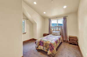 Bedroom featuring carpet and lofted ceiling