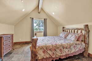 Bedroom with tile patterned floors and vaulted ceiling