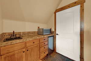 Bathroom featuring lofted ceiling, tile patterned floors, and sink