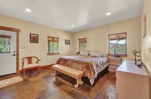 Bedroom featuring dark tile patterned floors and multiple windows