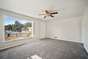 living room featuring new carpet and ceiling fan