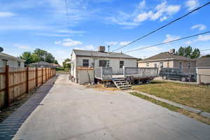 Rear view of house with a deck and a yard