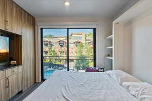 Bedroom featuring multiple windows, dark hardwood / wood-style flooring, and access to outside