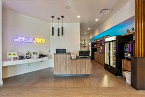 Kitchen with decorative light fixtures, hardwood / wood-style floors, and a kitchen island