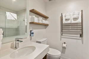 Bathroom with vanity, radiator heating unit, and toilet