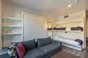 Bedroom featuring dark wood-type flooring and a closet