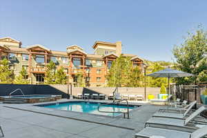 View of swimming pool featuring a patio and a hot tub