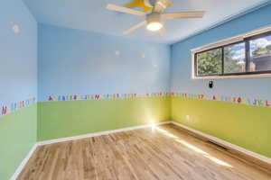 Unfurnished room featuring ceiling fan and light hardwood / wood-style flooring