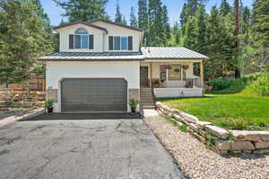 View of front of house featuring covered porch, a garage, and a front lawn