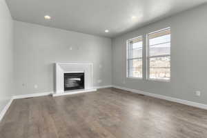 Unfurnished living room with hardwood / wood-style floors and a textured ceiling