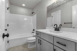 Full bathroom with tile patterned flooring, vanity, toilet, and shower / washtub combination