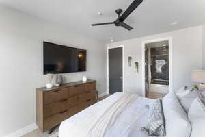 Bedroom featuring light hardwood / wood-style floors, connected bathroom, and ceiling fan