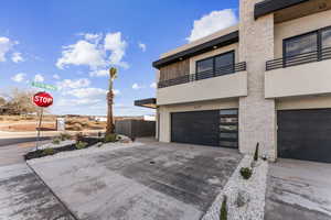 View of property exterior featuring a balcony and a garage