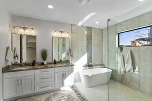 Bathroom featuring shower with separate bathtub, tile walls, dual vanity, and tile patterned floors