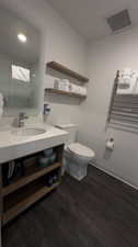 Bathroom with vanity, hardwood / wood-style flooring, and toilet