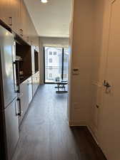 Kitchen with dark hardwood / wood-style flooring and stainless steel refrigerator