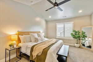 Primary Bedroom with ceiling fan, carpet, and lofted ceiling