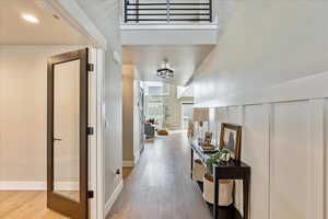 Hall with wood-type flooring and vaulted ceiling