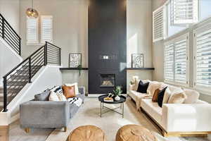 Living room featuring a fireplace, a high ceiling, and light hardwood / wood-style flooring