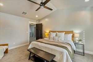 Carpeted bedroom featuring ceiling fan and lofted ceiling