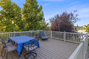 Generously sized open deck with views of lake and mountains, has main level sliding door access from kitchen, and stairs leading to patio and yard