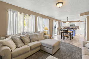 Living room with updated carpet, built in entertainment shelving, and bright windows