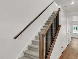 Staircase featuring hardwood / wood-style flooring