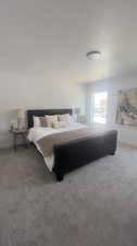 Bedroom with a textured ceiling and light colored carpet