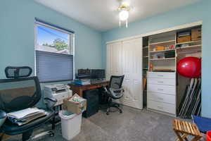 Carpeted office space featuring ceiling fan