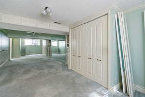 Interior space with carpet floors, crown molding, and a textured ceiling