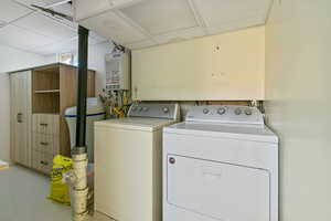 Clothes washing area featuring independent washer and dryer and tankless water heater