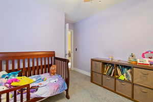 Carpeted bedroom featuring ceiling fan