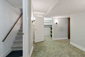 Stairs featuring carpet floors and a textured ceiling