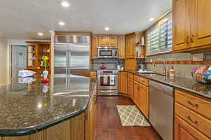 Kitchen featuring sink, dark hardwood / wood-style floors, stainless steel appliances, and backsplash