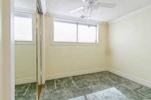 Unfurnished room featuring a textured ceiling, ceiling fan, and crown molding