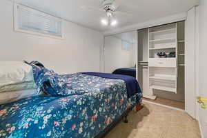 Carpeted bedroom featuring a closet and ceiling fan