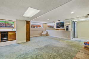 Interior space featuring a textured ceiling, bar area, and light tile patterned floors