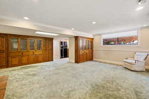 Interior space featuring light carpet, a textured ceiling, and crown molding