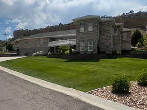 View of back of property with a garden box and lawn