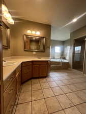 Master Bathroom featuring tiled tub, tile patterned floors, and double sink vanity