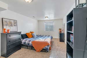 Bedroom featuring light carpet and a textured ceiling