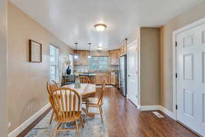 Dining room with wood-type flooring, sink, and a textured ceiling